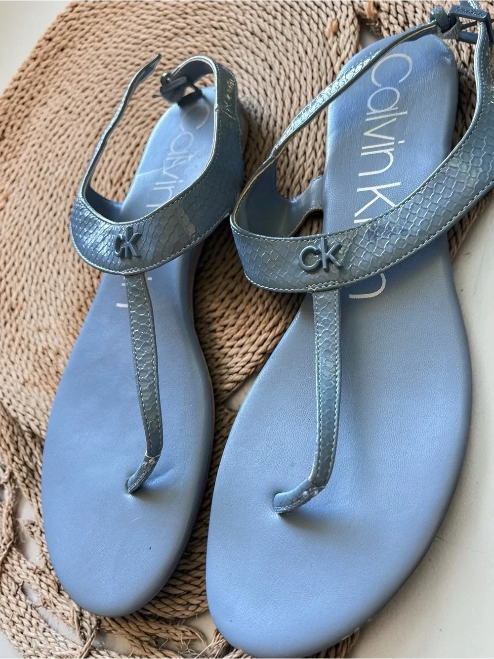 Calvin Klein Shellie blue snake print flat thong sandals feature an ankle strap
